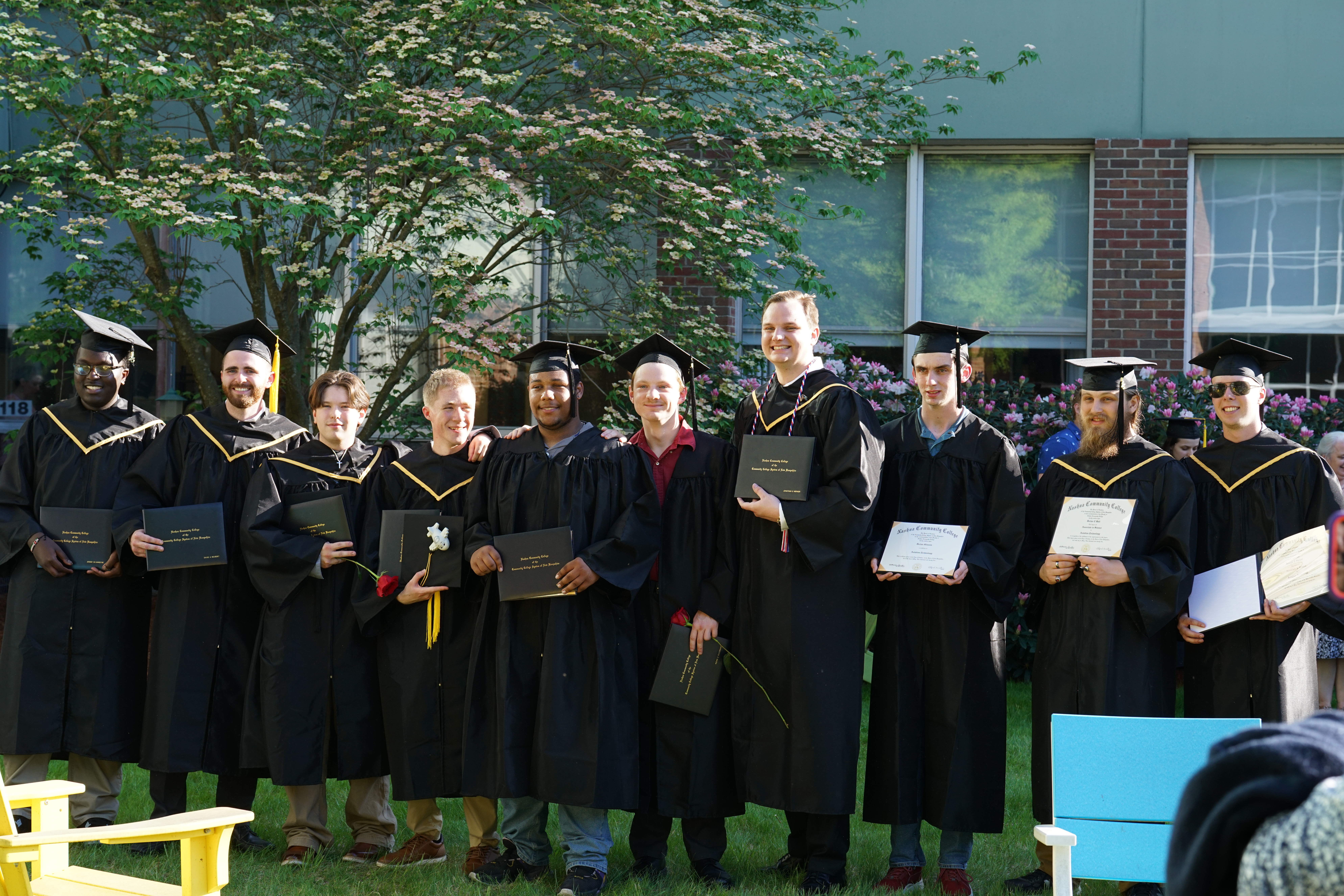 Graduates showing off their degrees in the NCC courtyard after Commencement