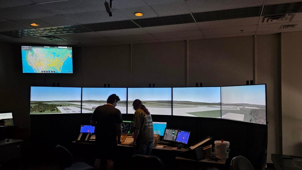 Two students use the Tower Simulator in a darkened classroom at NCC