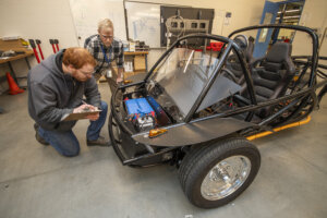Students and instructors review one of the Electric Vehicles in the NCC Automotive Lab