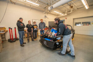 Students and instructors review one of the Electric Vehicles in the NCC Automotive Lab